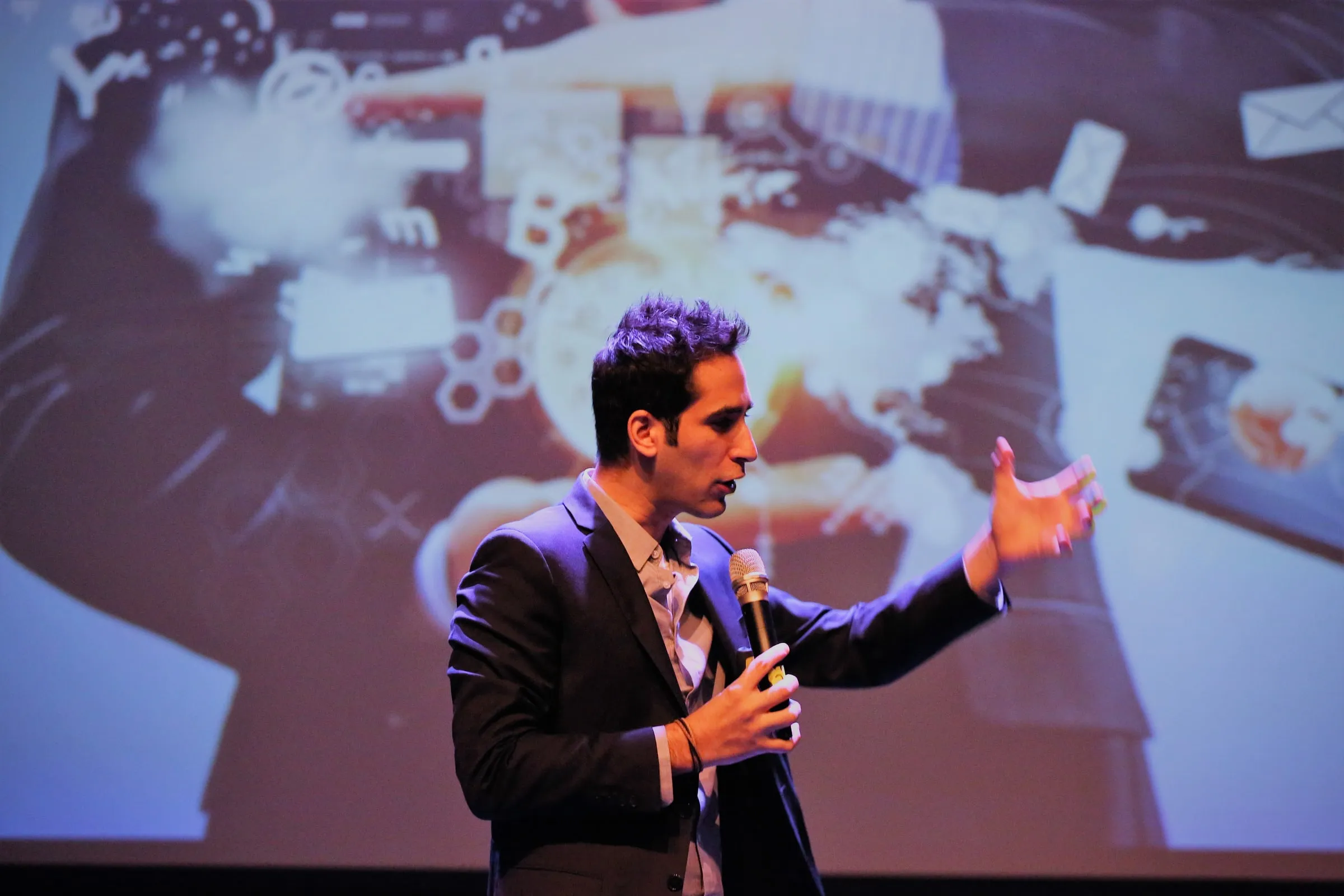 Menny Barzilay speaking in front of a large projection