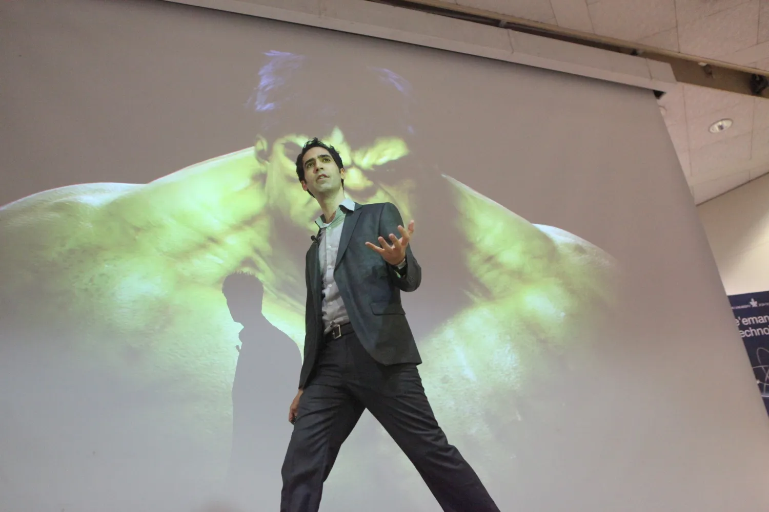 Menny Barzilay walking across a stage mid-talk